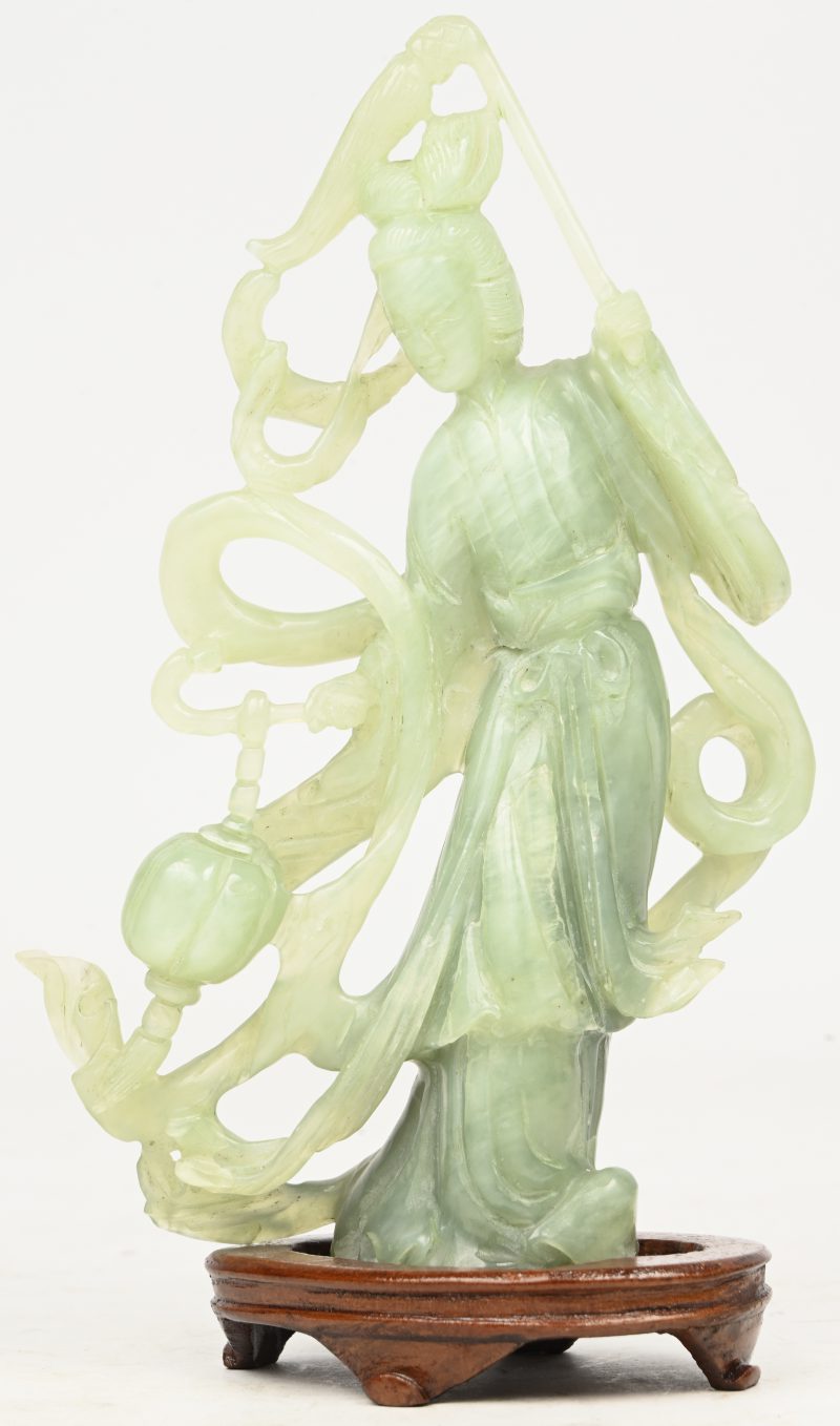 “Guanyin”. Een Chinees gesculpteerd beeldje in Jade op houten sokkeltje.