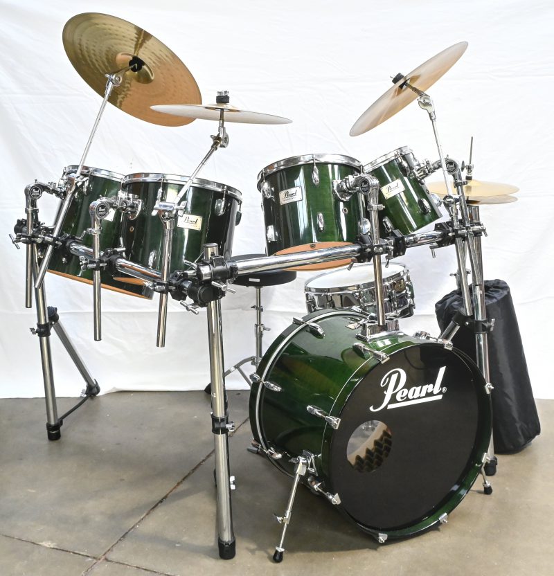 Een groenkleurig drumstel, gemerkt Pearl. Bestaande uit; 4 Toms en stands, Bas en pedal, Snare en stand, 4 cimbalen, Dixon rack, trone, tapijt. Vellen gemerkt Remo Weatherking Ambassador.