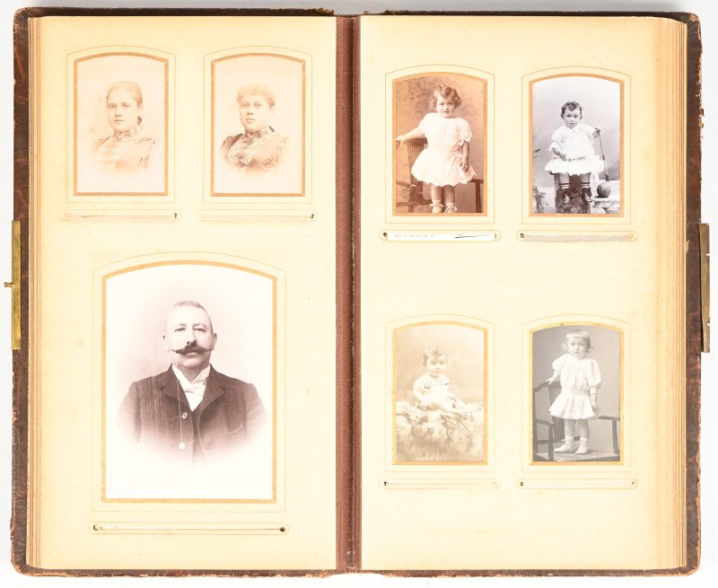 Een antiek fotoboek met lederen kaft grotendeels gevuld met oude foto’s, circa 1900. Een deel van het slot ontbreekt.