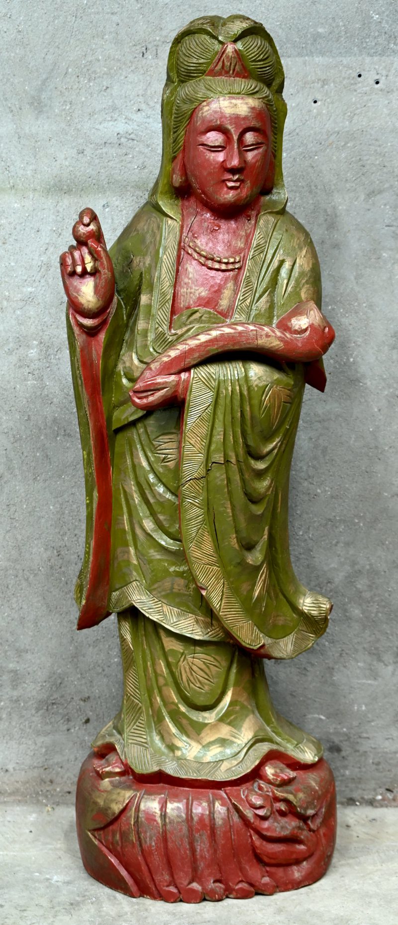 Een massief houtgesculpteerde Guanyin in bordeaux en groen.