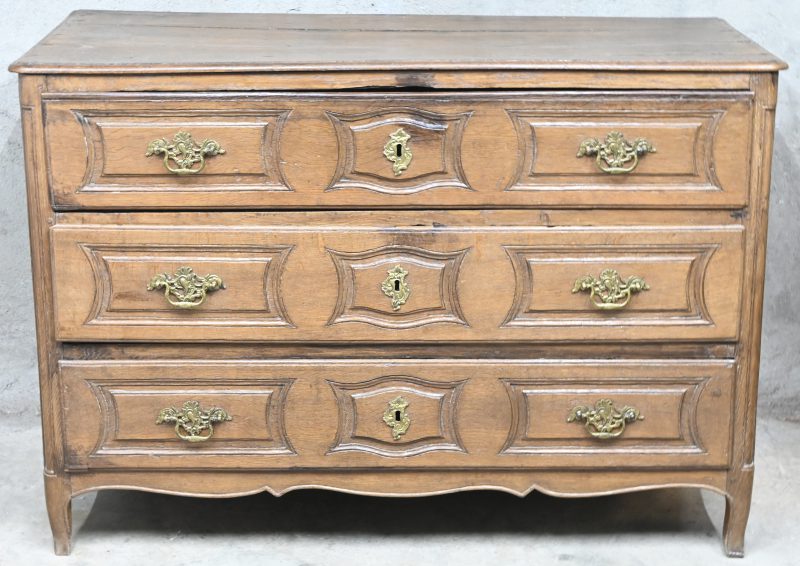 Een massief eikenhouten 19e eeuwse commode met bronzen handvatten.