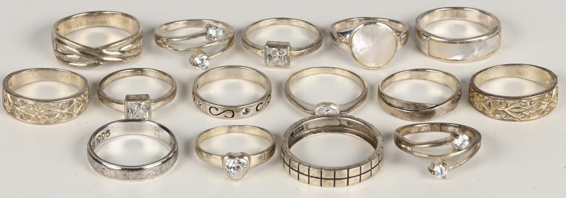 Vijftien verschillende zilveren ringen, sommige bezet met fantasiestenen en twee met parelmoer.