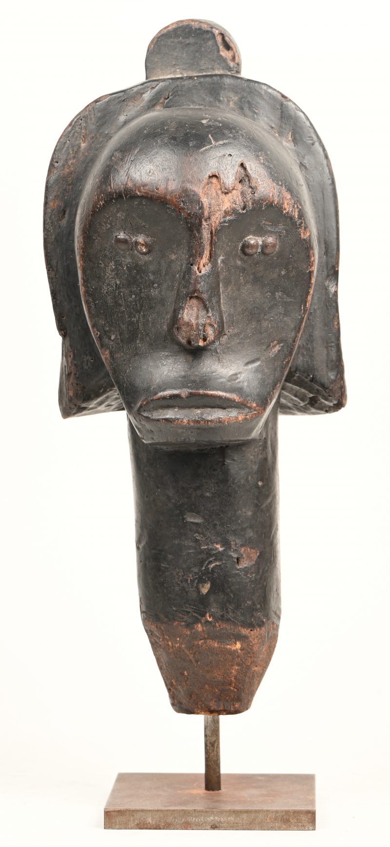 Een gesculpteerd houten beeldje van een Afrikaans masker.