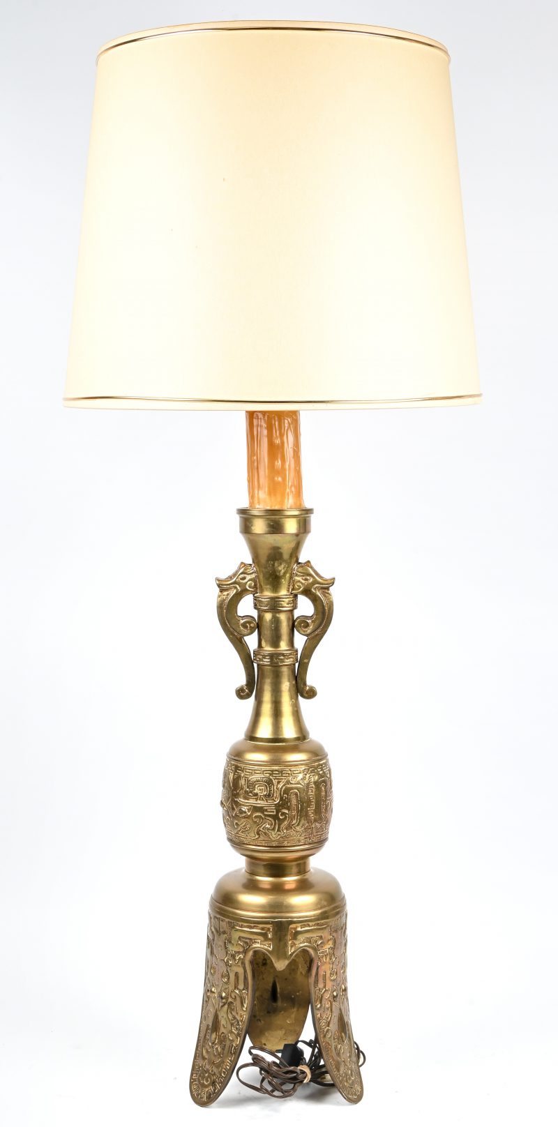 Een koperen staande lamp met oud Zuid-Amerikaans decor in het reliëf.