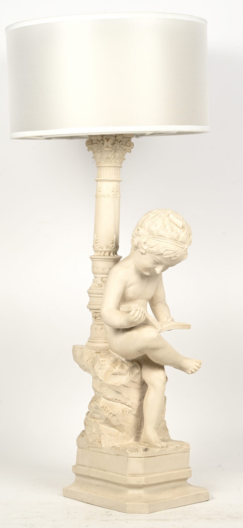 Een tafellamp in kunsthars voorstellend een lezende putto.