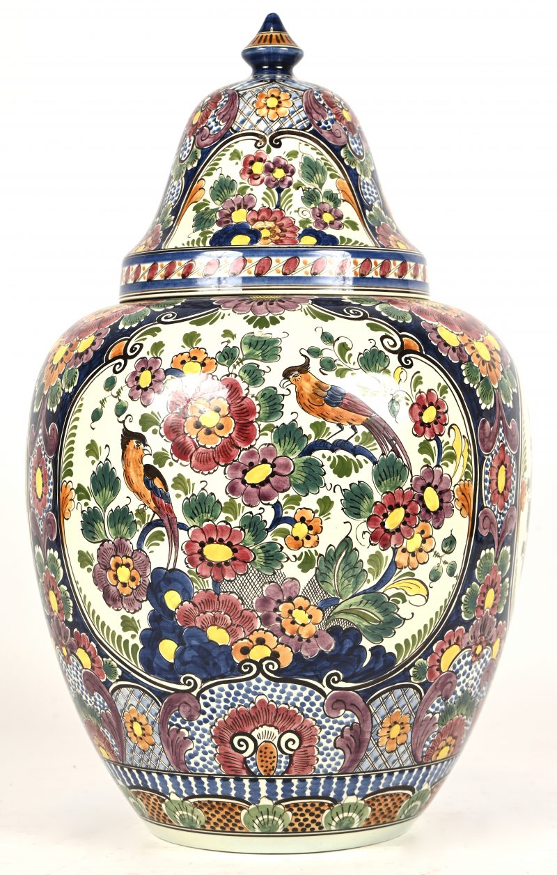 Een porseleinen dekselvaas onderaan gemerkt: Delft polychrome handpainted met florale motieven en vogels.