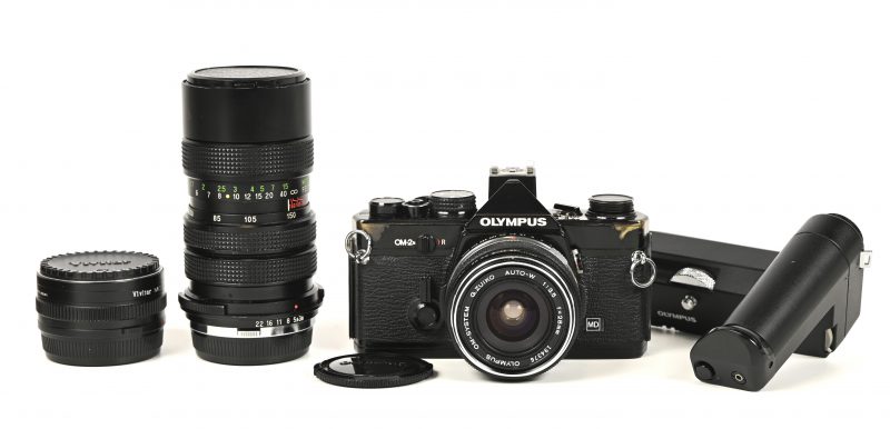 Een analoog fototoestel, Olympus OM-2n met 2 lenzen, Olympus 1:3.5/f=28mm en Vivitar 70-150mm 1:3.8 + motordrive en convertor.