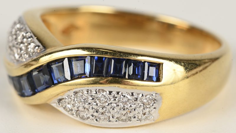 Een 18 kt geelgouden ring bezet met briljanten met een gezamenlijk gewicht van +- 0,20 ct. en saffieren met een gezamenlijk gewicht van +- 0,60 ct.