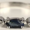 Een 18 kt witgouden ring bezet met twee kleine briljantjes en een saffier van +- 0,10 ct.