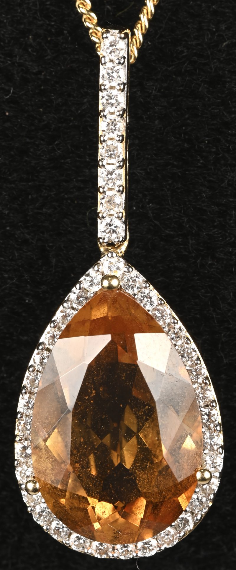 Een 18 kt geelgouden ketting met hanger bezet met briljanten met een gezamenlijk gewicht van +- 0,40 ct. en een centrale citrine van +- 5 ct.