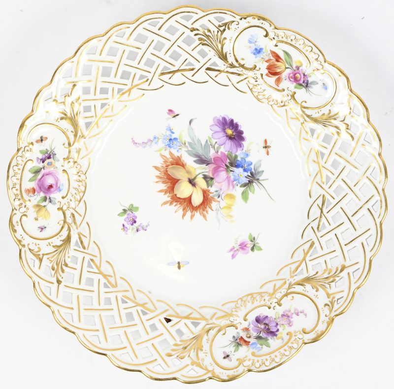 Porseleinen bordje gedecoreerd met bloemen en insecten. Draagt het Meissen merk.