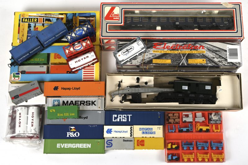 Een lot HO modeltrein toebehoren bestaande uit containers, brandstoftanks, klein rollend materiaal, 2 wagons van het merk Lima en een spoorkraan van Roco.