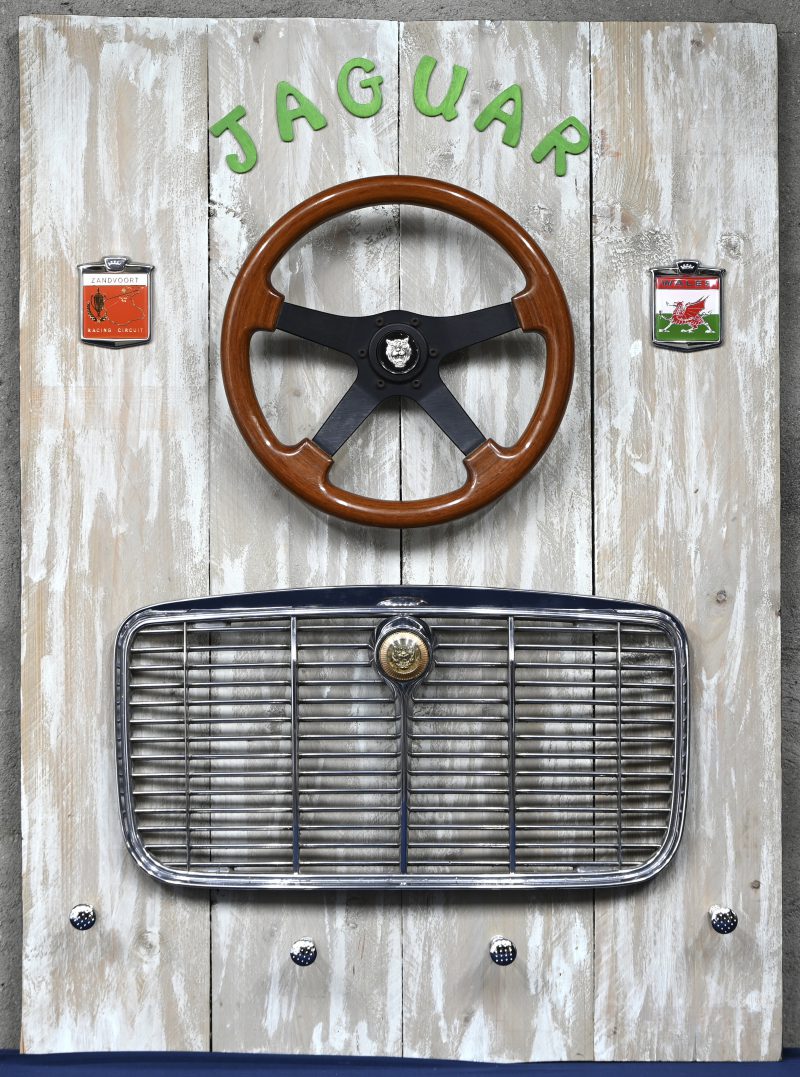 Stuurwiel, radiatorrooster en attributen van een oude wagen.