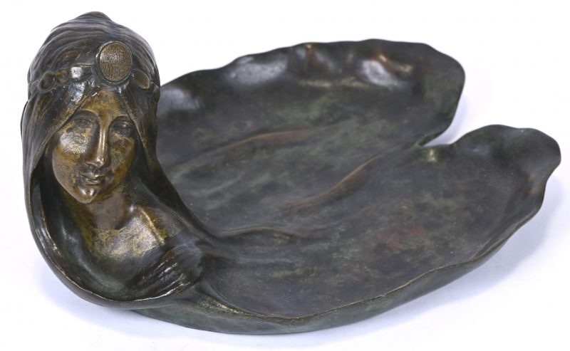 Een bronzen art nouveau vide-poche in de vorm van een waterlelie blad en een meisjeshoofd.