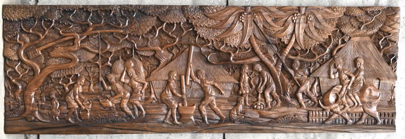 Een massief houten gesculpteerd paneel met figuren en het decor, Indonesisch werk.