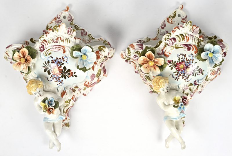 Paar Bassano wandvazen. Versierd met putti en  bloemen. Kleine schade aan enkele bloemblaadjes.