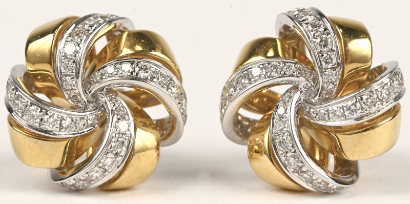 Een paar 18 kt wit en geelgouden oorbellen met briljanten met een gezamenlijk gewicht van +- 0,48 ct.
