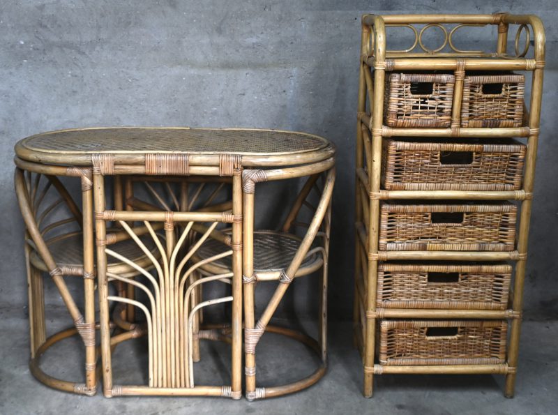 Een opbergmeubel van rotan met bijpassende tafel en twee stoelen.