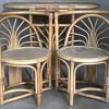 Een opbergmeubel van rotan met bijpassende tafel en twee stoelen.
