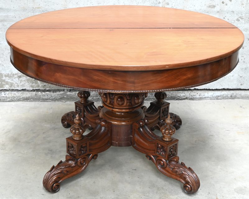 Een verlengbare ronde massief houten tafel met centrale gesculpteerde voet? Inclusief 4 verlengstukken.