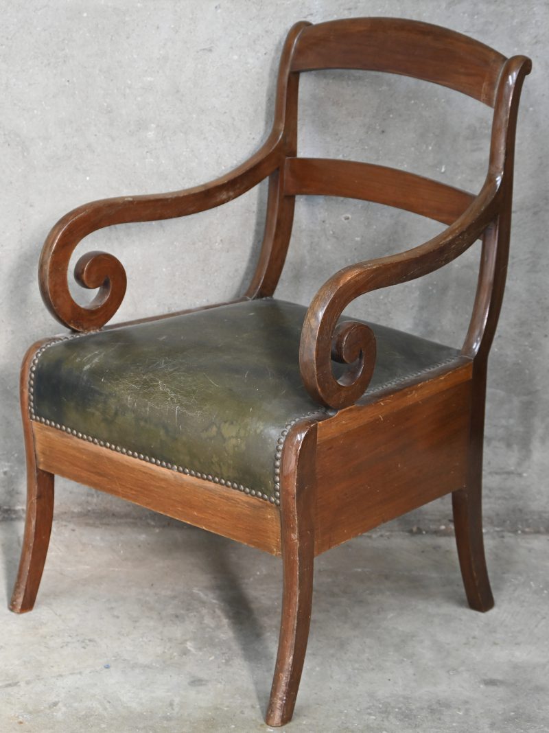 Klassieke houten armstoel met groene lederen zitting.