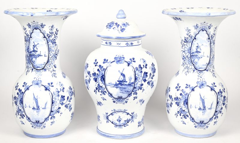 Drie delige schouwgarnituur bestaande uit een een dekselvaas en twee kraagvazen in blauw-wit Delfts aardewerk.