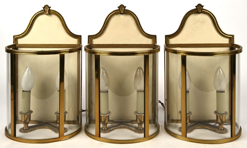 Set van drie lantaarnvormige wandlampen, in messing en glas.