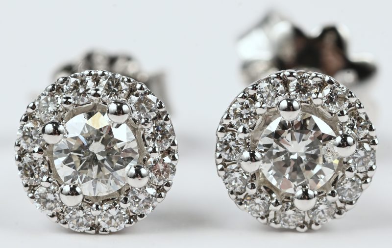 Een paar 18 kt witgouden oorbellen bezet met beide een centrale briljant van totaal 0,36 ct. FVS. en briljanten met een gezamenlijk gewicht van +- 0,24 ct. FVS.