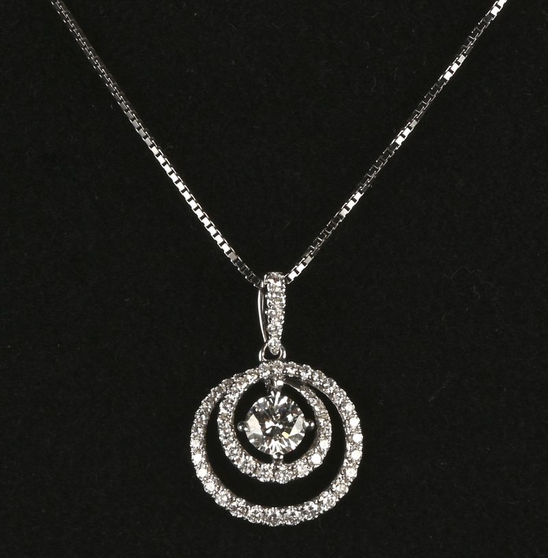 Een 18 kt witgouden ketting met hanger bezet met een centrale briljant van +- 0,56 ct. HVS2. en briljanten met een gezamenlijk gewicht van +-0,64 ct. FVVS.