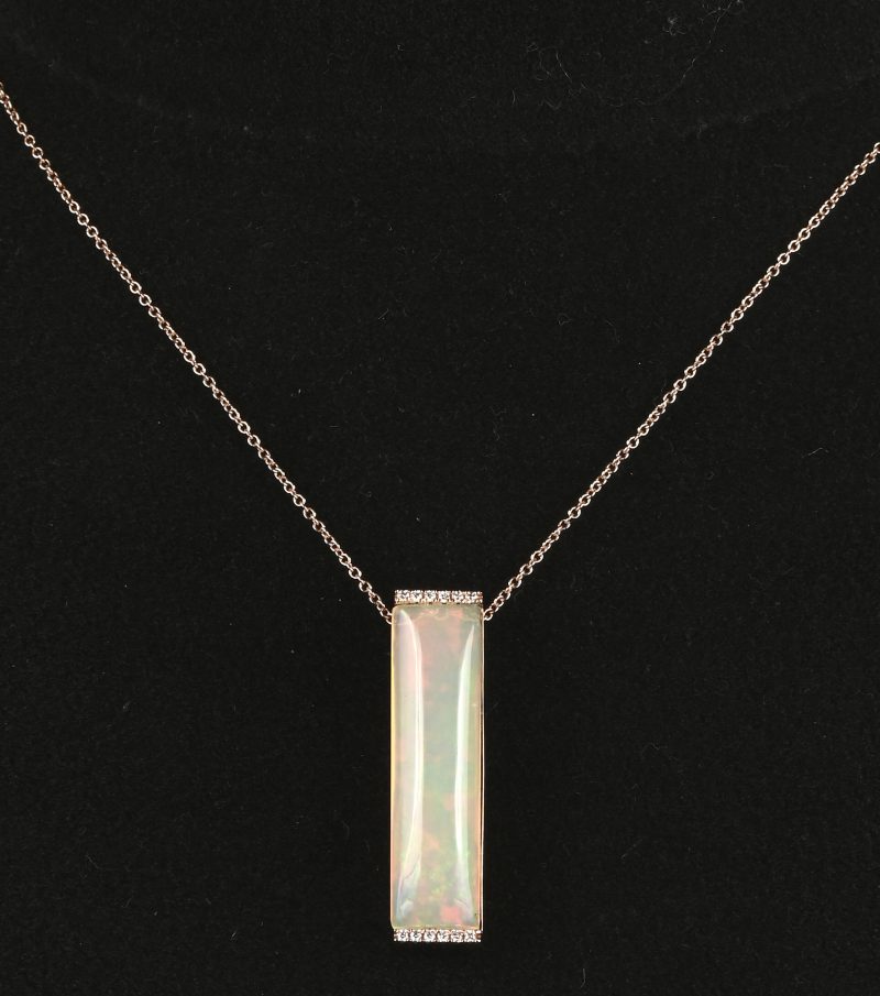 Een 18 kt roze gouden ketting met hanger bezet met een langwerpige opaal van 12,56 ct. en kleine briljantjes. Met certificaat.