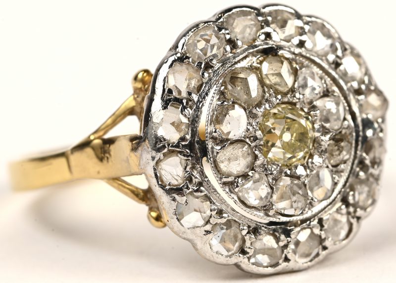 Een 18 kt wit en geelgouden ring bezet met een centrale gele diamant en diamanten oude slijp met een gezamenlijk gewicht van +- 1 ct.