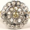 Een 18 kt wit en geelgouden ring bezet met een centrale gele diamant en diamanten oude slijp met een gezamenlijk gewicht van +- 1 ct.