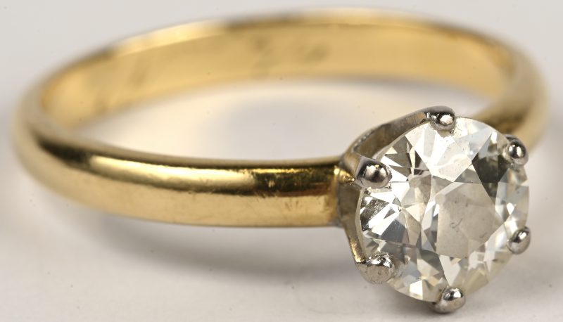 Een 18 kt wit-en geelgouden ring bezet met diamant solitair van +- 1,25 ct.