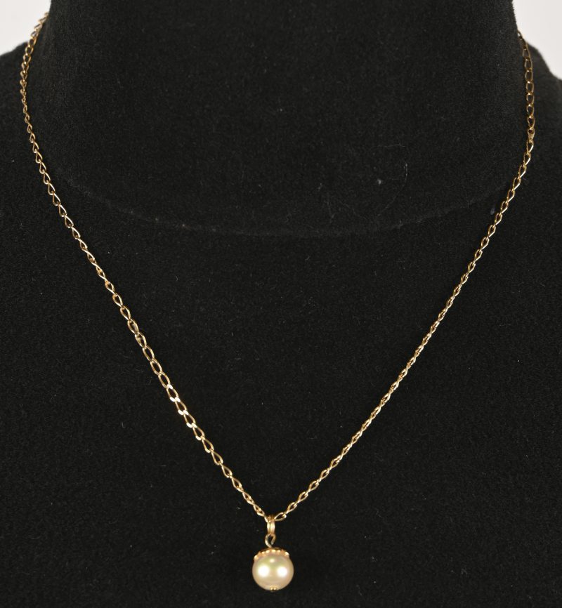Een 18 kt geelgouden ketting met hanger bezet met een parel.