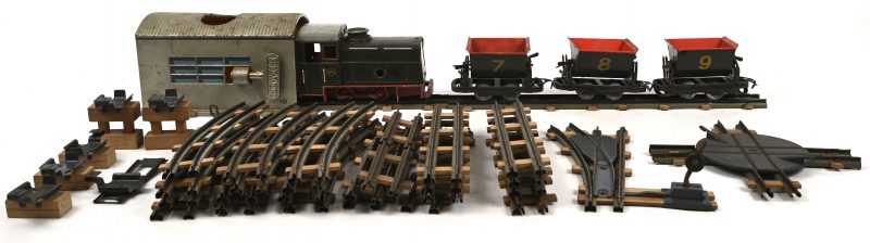 Een vintage opwindbare treinset van het merk Biller, HO spoor, bestaande uit een locomotief met 3 wagons, een lot sporen en het bijhorende opwindstation.