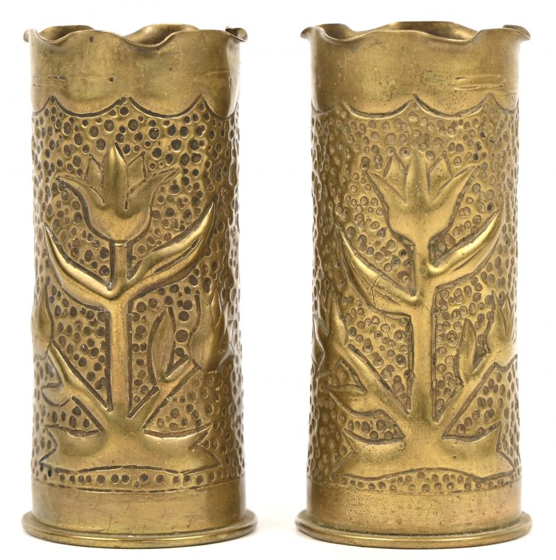 Set trench art vaasjes. Gedecoreerd met bloemen en de cijfers 19 en 22. Gemaakt van Duitse obussen, gestempeld 1903 en 1905.