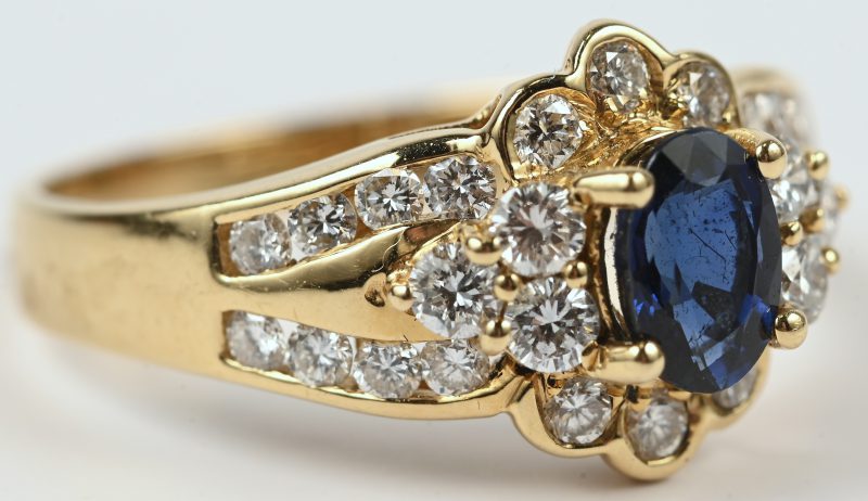 Een 18 karaats geelgouden ring bezet met briljanten met een gezamenlijk gewicht van +- 0,50 ct. een centrale saffier van +- 0,50 ct.