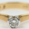 Een 18 kt wit en geelgouden ring bezet met een solitair van +- 0,25 ct.