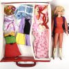Een vintage Barbiepop met een lot kledij in een vintage Barbie-draagkoffertje.