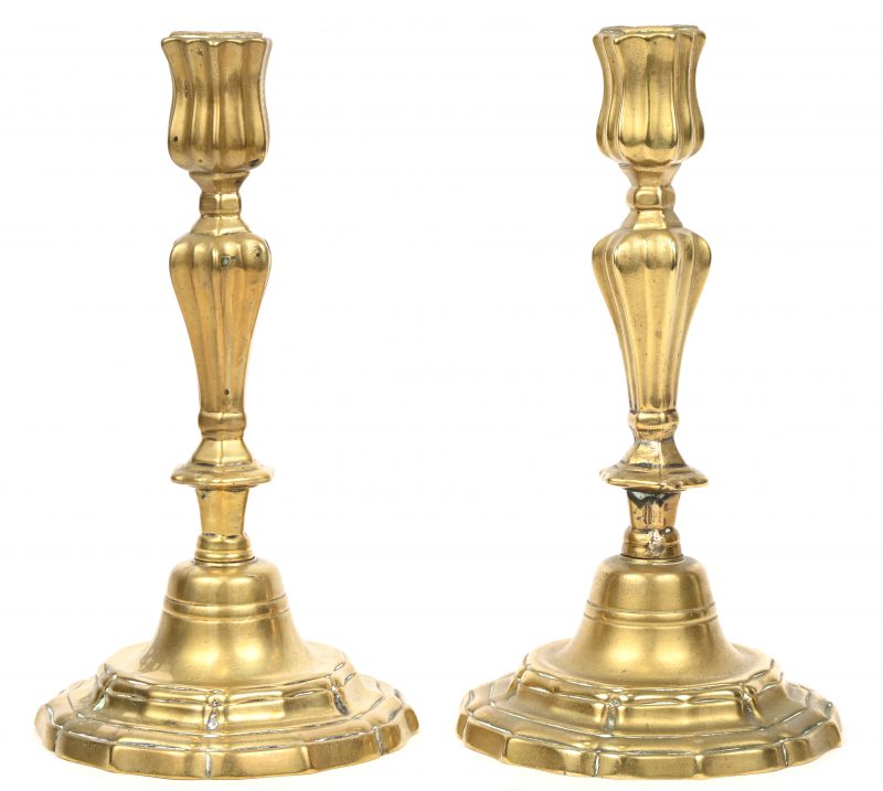 Een paar messingen Louis XV kandelaars, met bloemvormige voet.