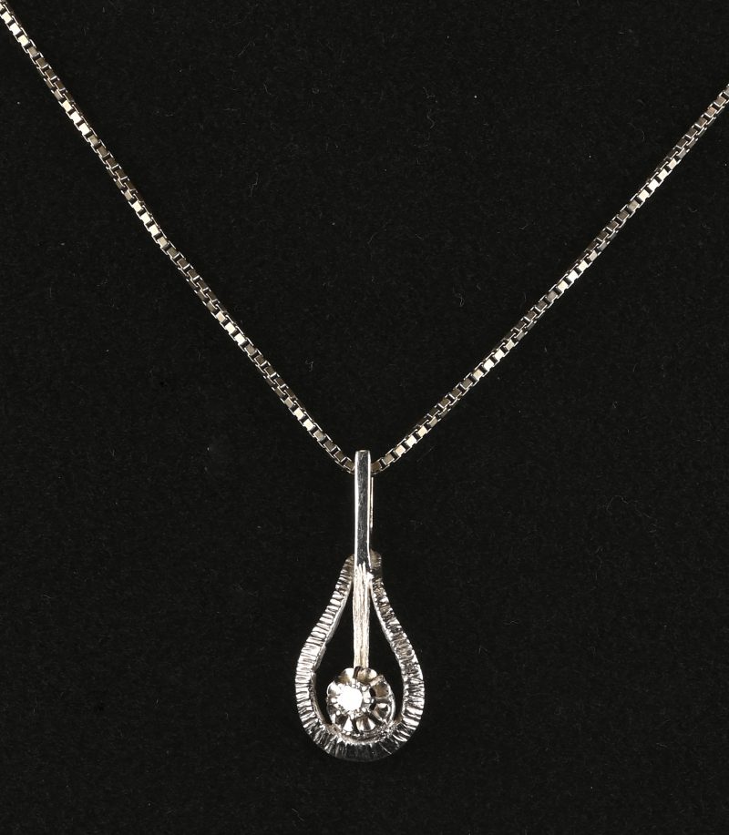 Een 18 kt witgouden ketting met hanger bezet met één briljant van +- 0,10 ct.