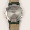 Een roestvrij stalen horloge met groen lederen gedragen polsband.