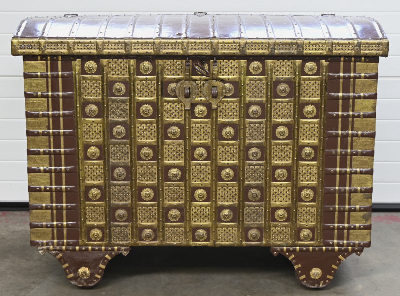 Zeer grote Indische bruidskoffer op wielen. Bekleed met beschilderd metaal en versierd met koperen rosetten en banden.