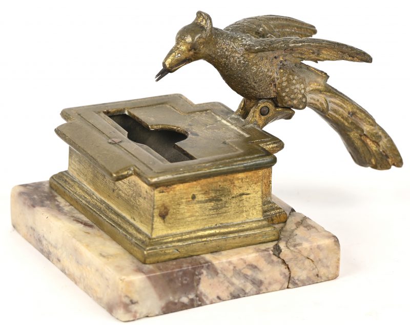 Bronzen luciferhouder met een vogel die een lucifer ‘pikt’. Op marmeren voet, met herstelling.