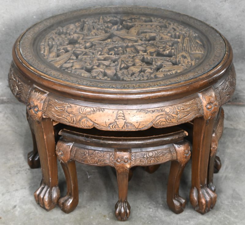 Gesculpteerde houten salontafel met een decor van strijdgewoel. Met 4 bijpassende wigvormige krukjes.