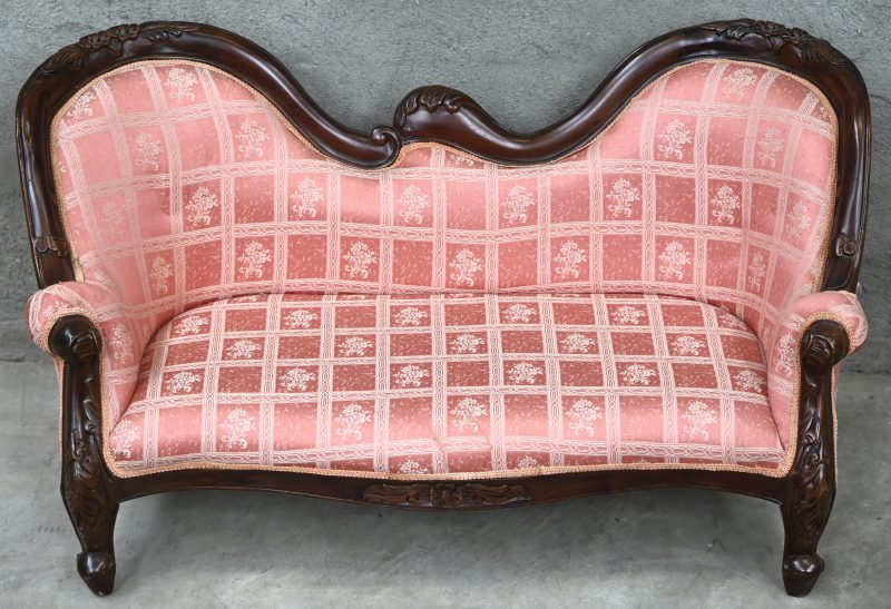 Een kinderzeteltje in romantische stijl, roze stoffen bekleding met florale motieven.