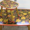 Een set van 2 Russische Khokloma handbelschilderde vintage tafeltjes met florale motieven.