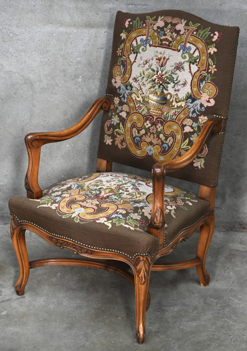 Een beukenhouten armstoel, bekleed met naaldwerk “petit point”.