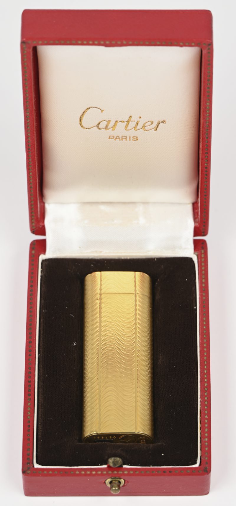 Een vergulde aansteker, gemerkt Cartier Paris, in origineel doosje, met papieren.
