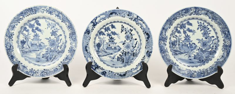 Een set van 3 Chinees porseleinen borden met een blauw op wit decor van een tuintje met pagode. Qianlong decor. Schilfer en haarlijn.